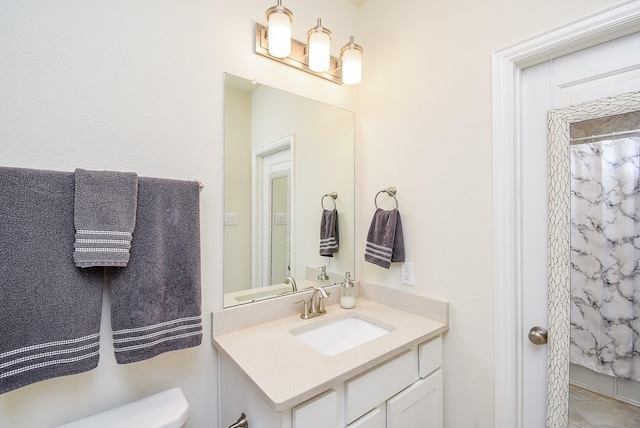 bathroom with toilet, vanity, and curtained shower