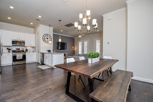 dining room with dark wood-type flooring, sink, ceiling fan with notable chandelier, and ornamental molding