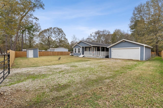 view of front facade featuring a garage, a front yard, and a storage shed