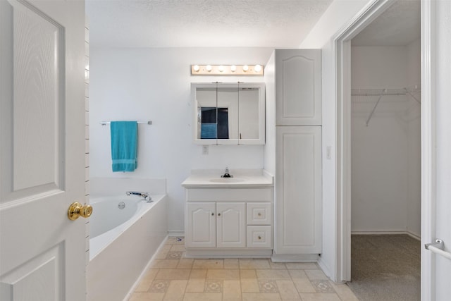 bathroom featuring vanity, a bath, and a textured ceiling