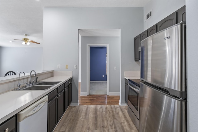 kitchen with sink, light hardwood / wood-style flooring, stainless steel appliances, and ceiling fan