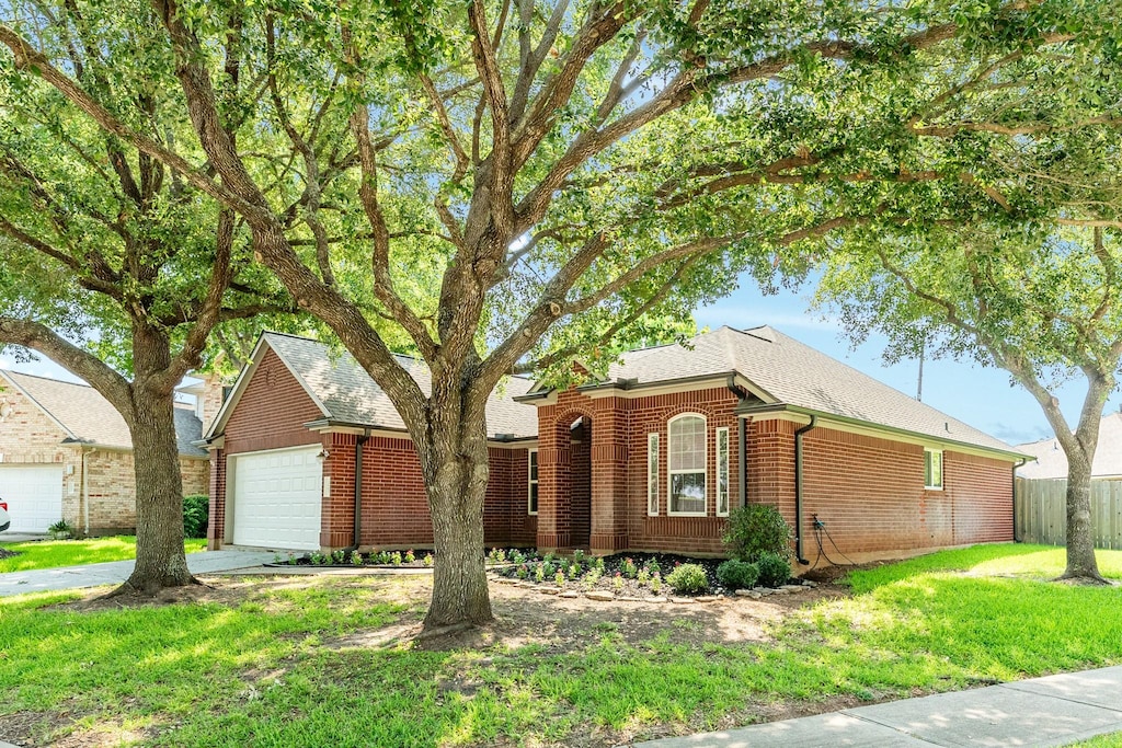 ranch-style house with a garage and a front yard