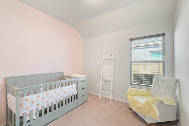 bedroom featuring light colored carpet, a nursery area, and lofted ceiling