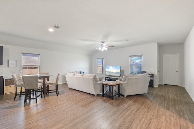 living room with light hardwood / wood-style floors, ceiling fan, and vaulted ceiling