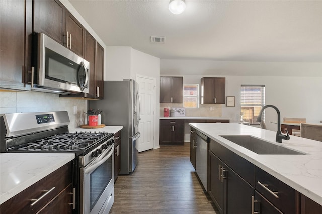 kitchen featuring stainless steel appliances, dark brown cabinets, dark hardwood / wood-style flooring, and sink