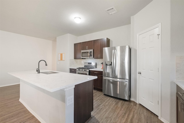 kitchen featuring sink, dark hardwood / wood-style floors, an island with sink, and stainless steel appliances