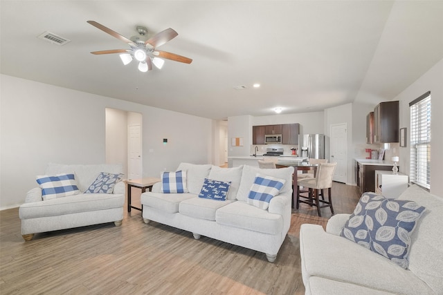 living room with ceiling fan and light hardwood / wood-style floors