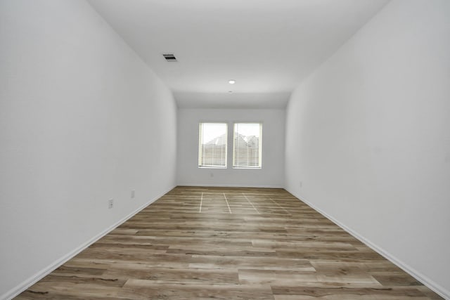 spare room with wood finished floors and visible vents