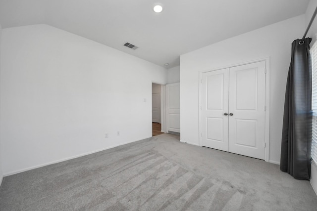 unfurnished bedroom featuring carpet, visible vents, and a closet