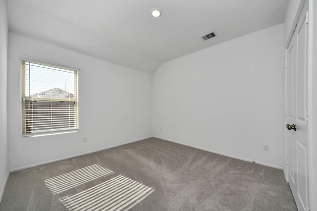 carpeted spare room featuring lofted ceiling, visible vents, and recessed lighting