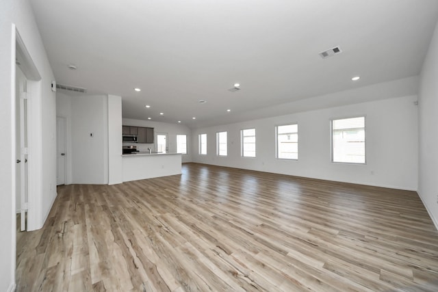 unfurnished living room with plenty of natural light, light wood-style flooring, and visible vents