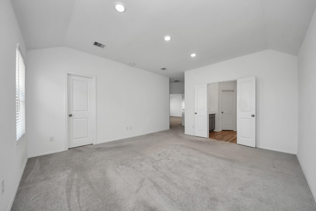 unfurnished bedroom featuring vaulted ceiling, carpet, visible vents, and recessed lighting