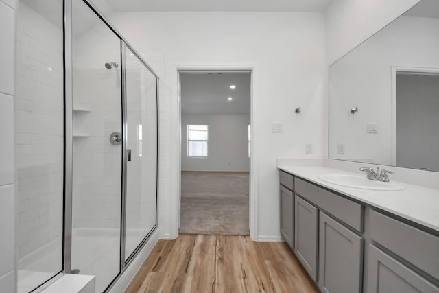 bathroom featuring a stall shower, vanity, and wood finished floors