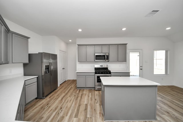 kitchen featuring appliances with stainless steel finishes, gray cabinets, visible vents, and light wood-style floors