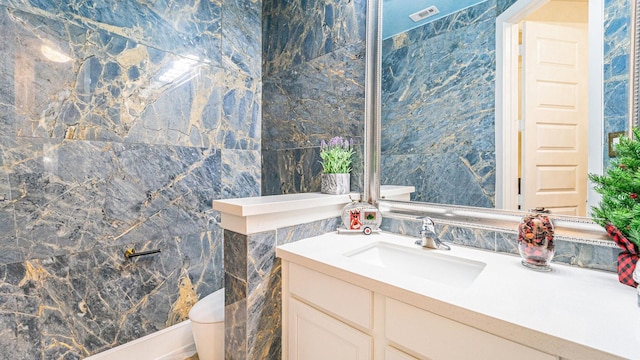 bathroom with vanity and tile walls