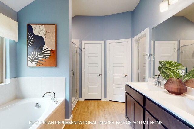 bathroom featuring double vanity, a stall shower, lofted ceiling, a garden tub, and a sink