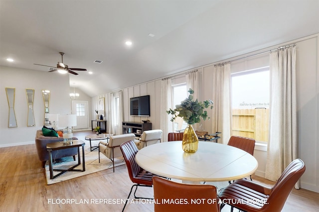 dining room featuring ceiling fan with notable chandelier, light wood-type flooring, vaulted ceiling, and recessed lighting