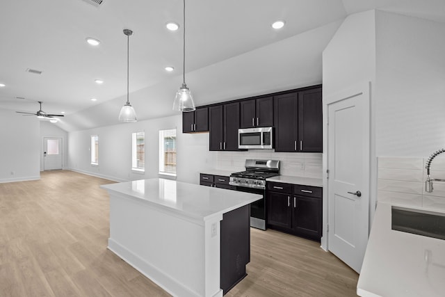 26240 Astral Way, La Marque, TX 77568 - kitchen with stainless steel appliances, vaulted ceiling, tasteful backsplash, a sink, and light wood finished floors