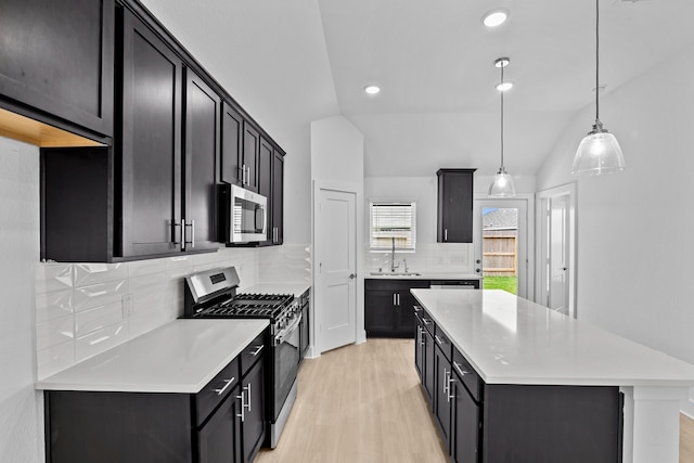 26240 Astral Way, La Marque, TX 77568 - kitchen with appliances with stainless steel finishes, a center island, light countertops, a sink, and light wood finished floors