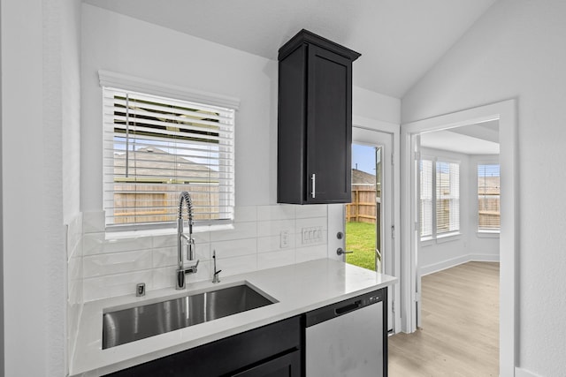 26240 Astral Way, La Marque, TX 77568 - kitchen with stainless steel dishwasher, dark cabinetry, a sink, light countertops, and vaulted ceiling