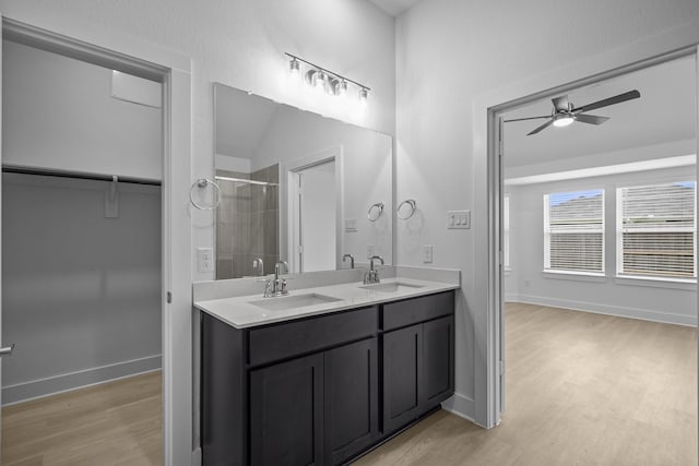 26240 Astral Way, La Marque, TX 77568 - bathroom with wood finished floors, double vanity, a ceiling fan, a tile shower, and baseboards