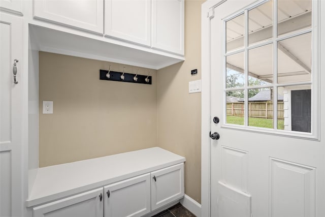 mudroom with dark tile patterned floors