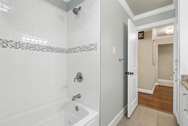 bathroom featuring tile patterned floors, vanity, crown molding, and tiled shower / bath