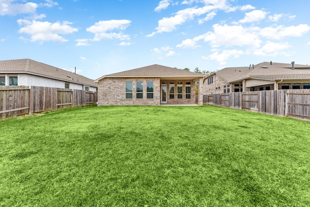 rear view of property featuring a lawn