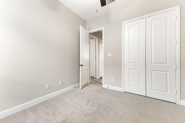 unfurnished bedroom with ceiling fan, light colored carpet, and a closet