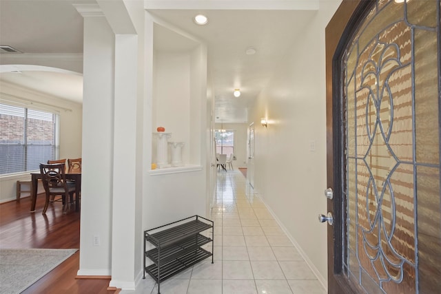 tiled foyer featuring crown molding