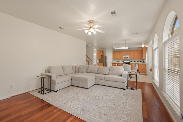 living room with light wood-type flooring and ceiling fan