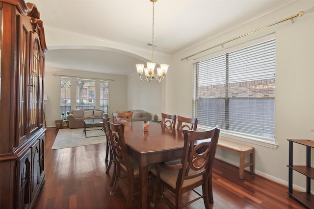 dining space with a notable chandelier, a healthy amount of sunlight, crown molding, and dark hardwood / wood-style flooring