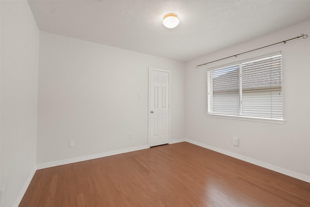 unfurnished room featuring hardwood / wood-style floors and a textured ceiling