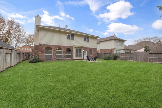 rear view of house with a lawn and a patio