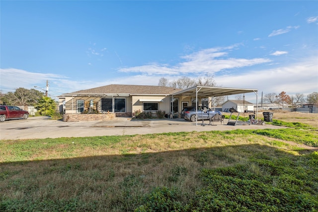 back of house featuring a carport and a yard