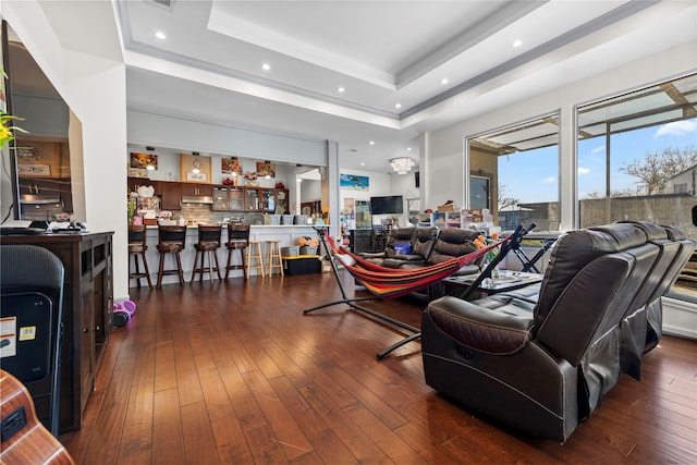 living room with dark hardwood / wood-style floors and a tray ceiling