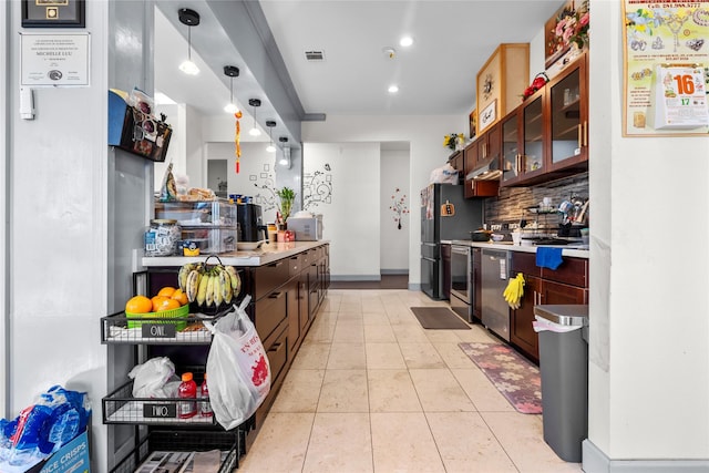 kitchen featuring tasteful backsplash, pendant lighting, light tile patterned flooring, dark brown cabinetry, and appliances with stainless steel finishes