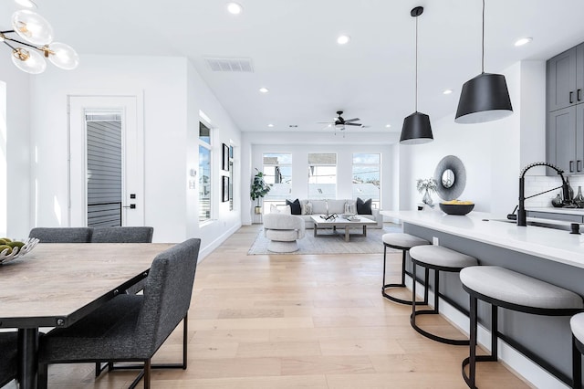 dining space featuring sink, ceiling fan, and light hardwood / wood-style floors