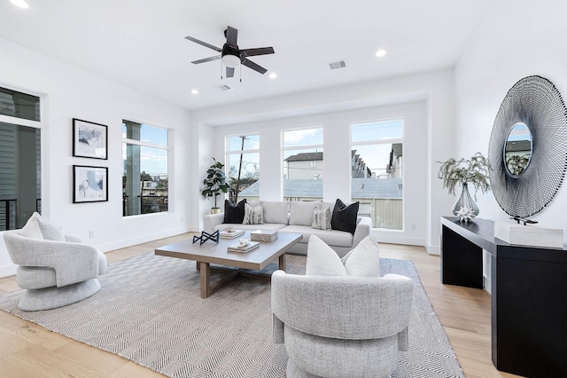 living room featuring ceiling fan and light hardwood / wood-style flooring