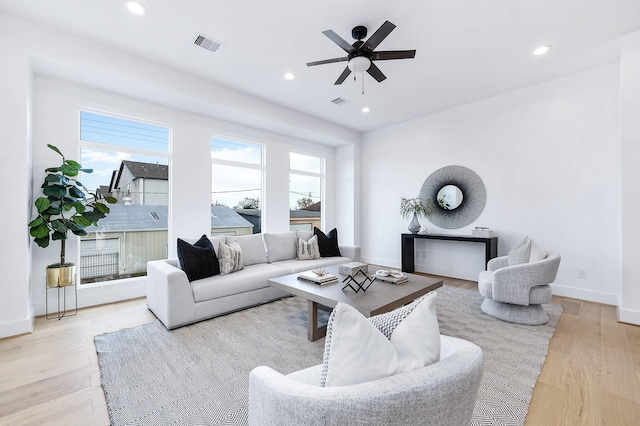 living room with ceiling fan, light hardwood / wood-style flooring, and a wealth of natural light