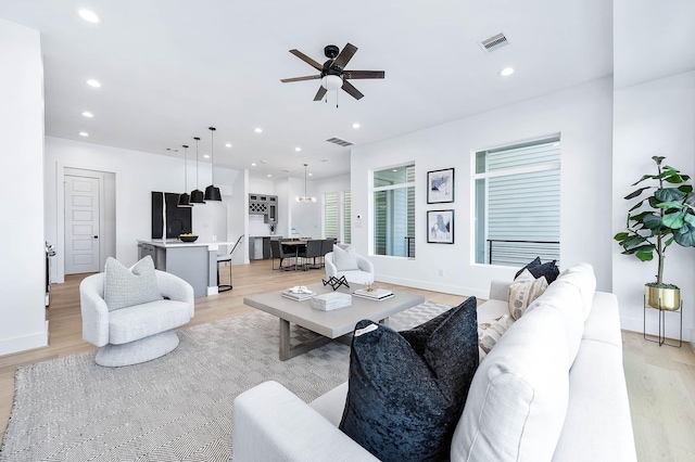 living room featuring ceiling fan and light hardwood / wood-style flooring