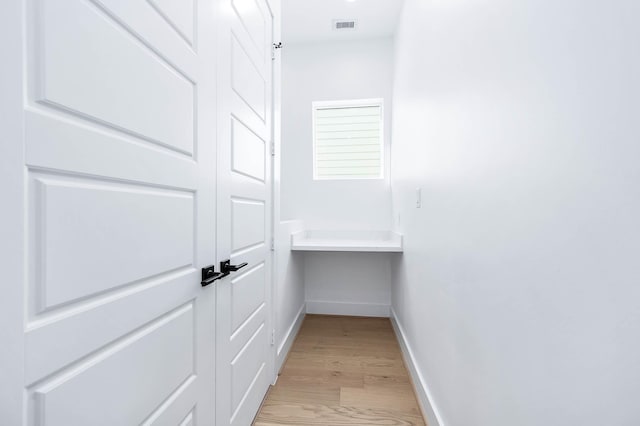 interior space featuring built in desk and light hardwood / wood-style flooring