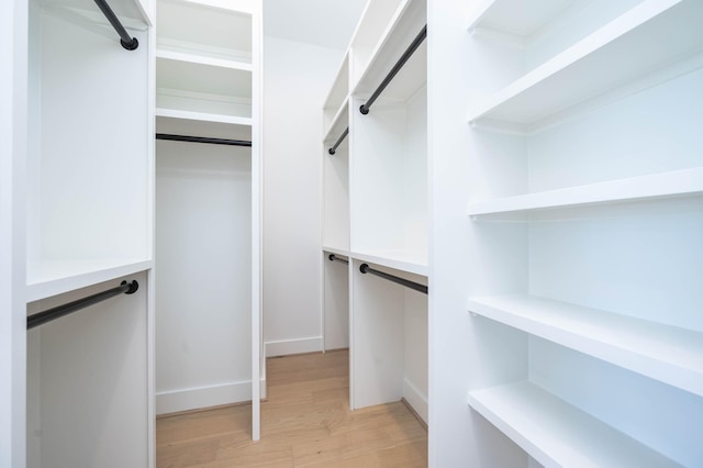 spacious closet with light hardwood / wood-style flooring