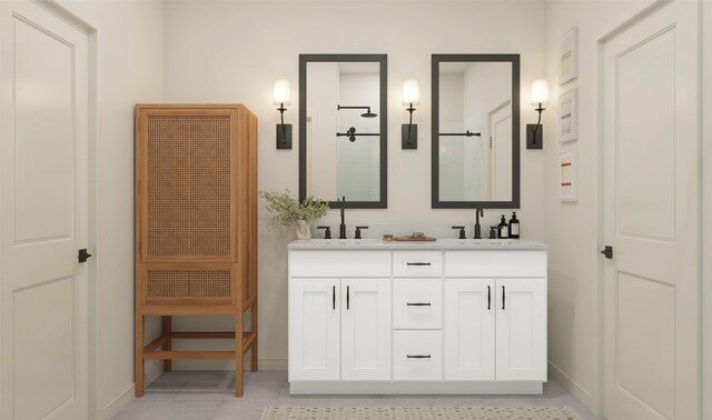 bathroom with a stall shower, a sink, baseboards, and double vanity
