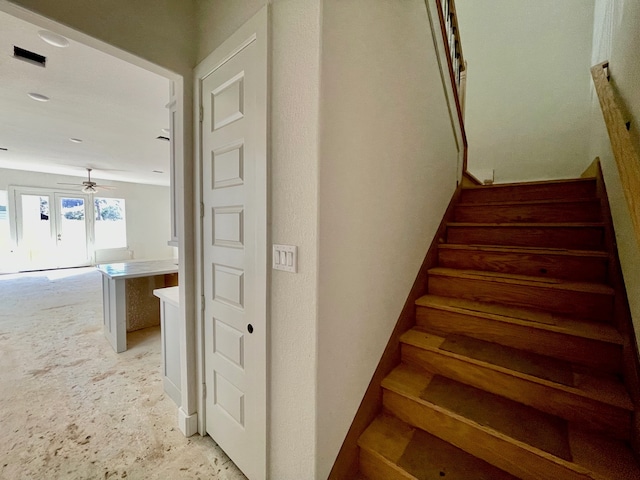 staircase featuring a ceiling fan