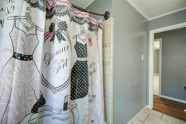 bathroom featuring tile patterned flooring, crown molding, and walk in shower