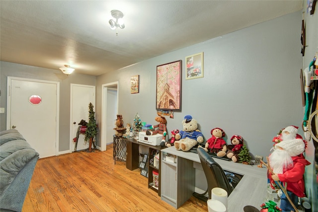 home office with light hardwood / wood-style flooring