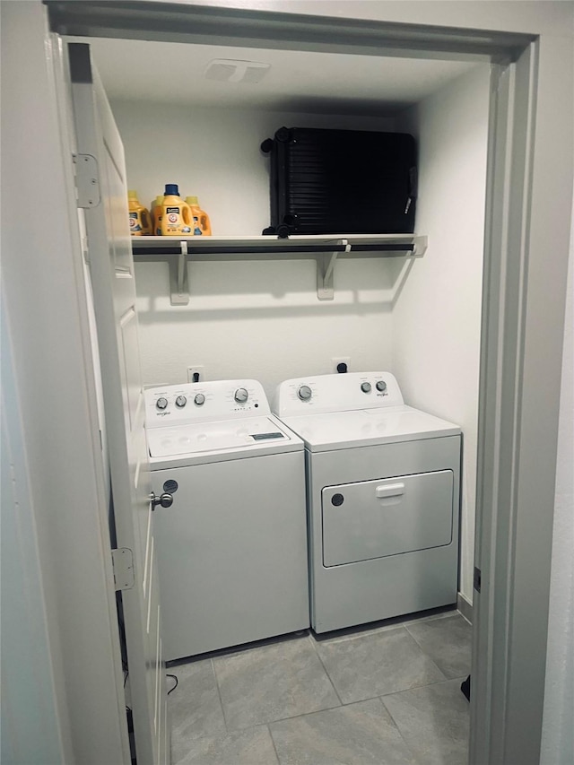 laundry room featuring washing machine and dryer and light tile patterned floors