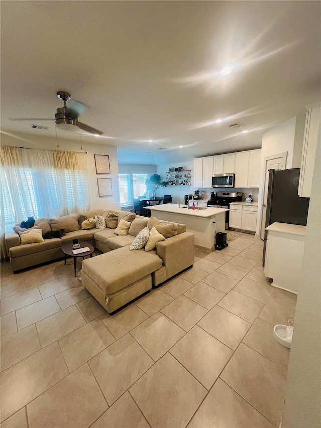 tiled living room with ceiling fan