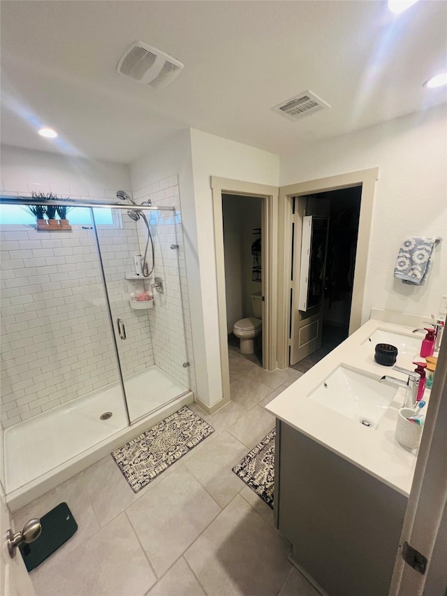 bathroom featuring walk in shower, tile patterned floors, toilet, and vanity